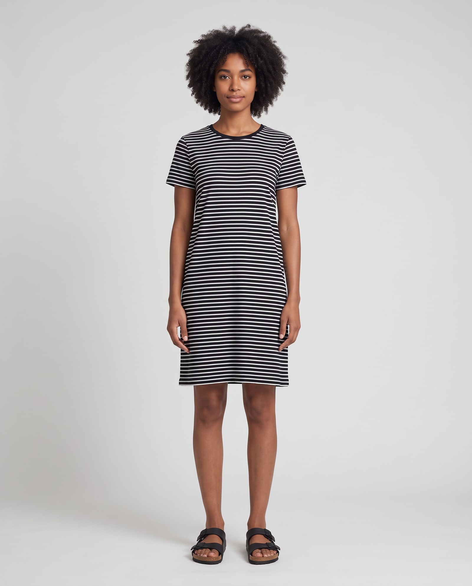 Model wearing the striped t-shirt dress in a light-grey studio