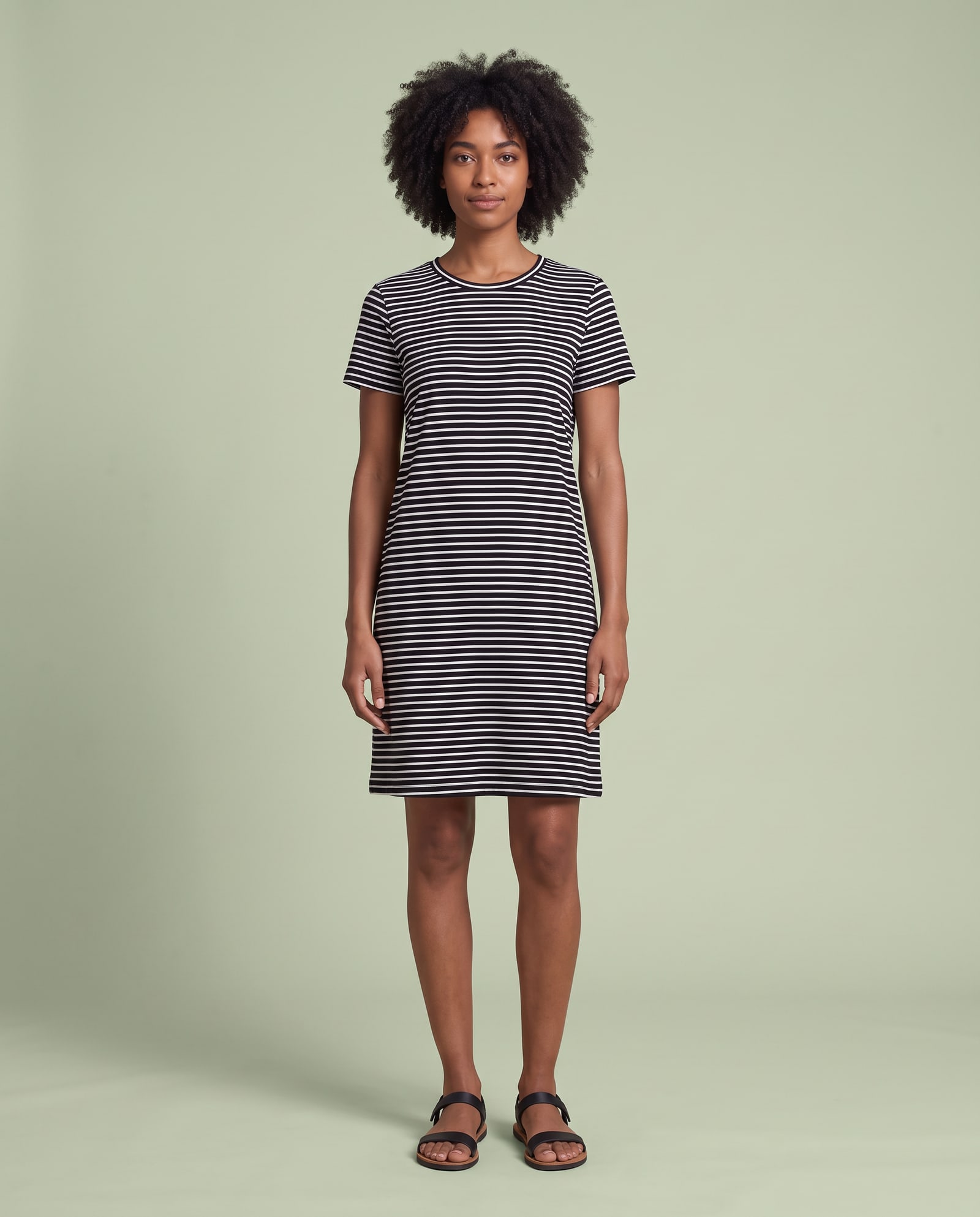 Model wearing the striped t-shirt dress in a pale sage studio