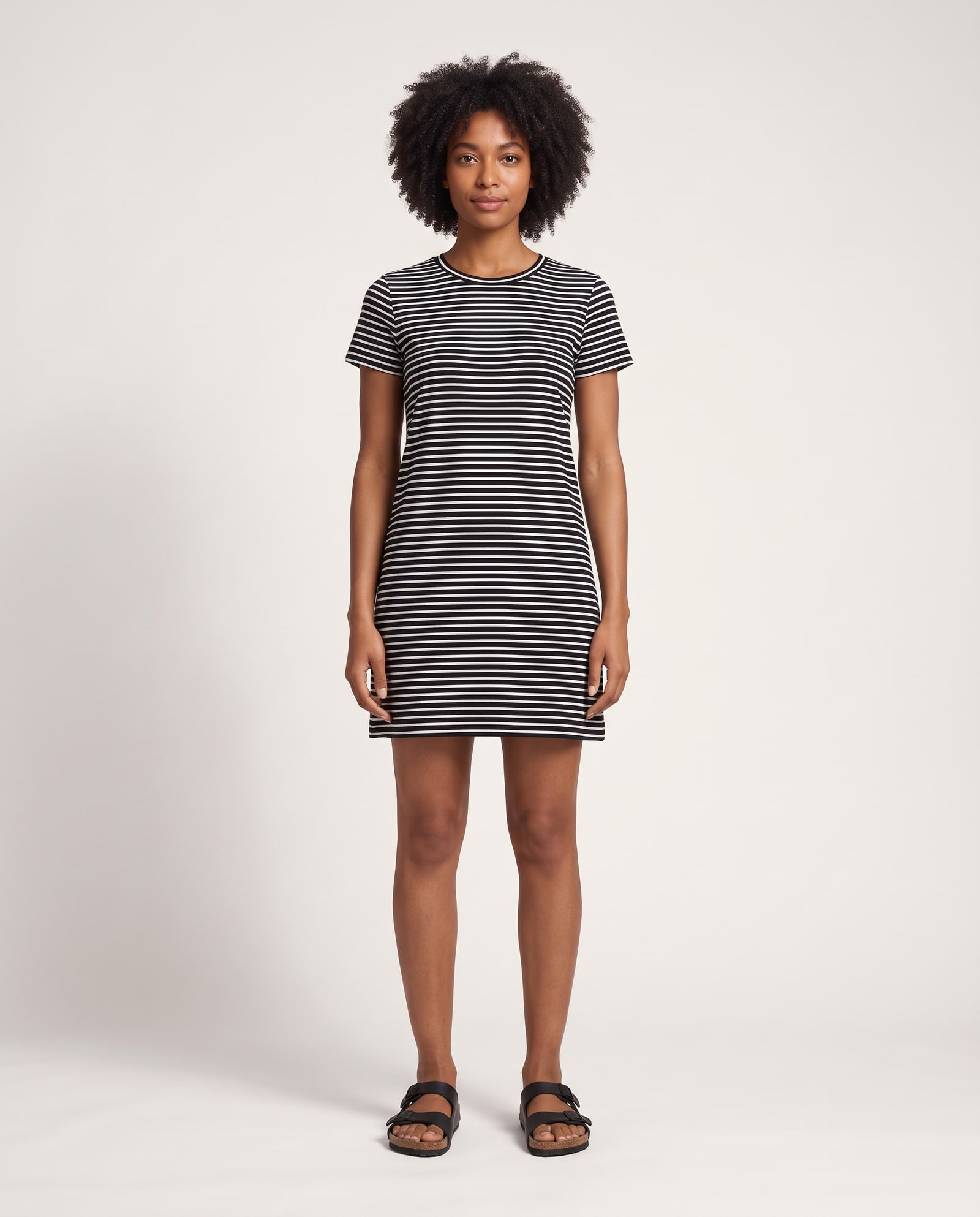 Model wearing the striped t-shirt dress in a soft white studio