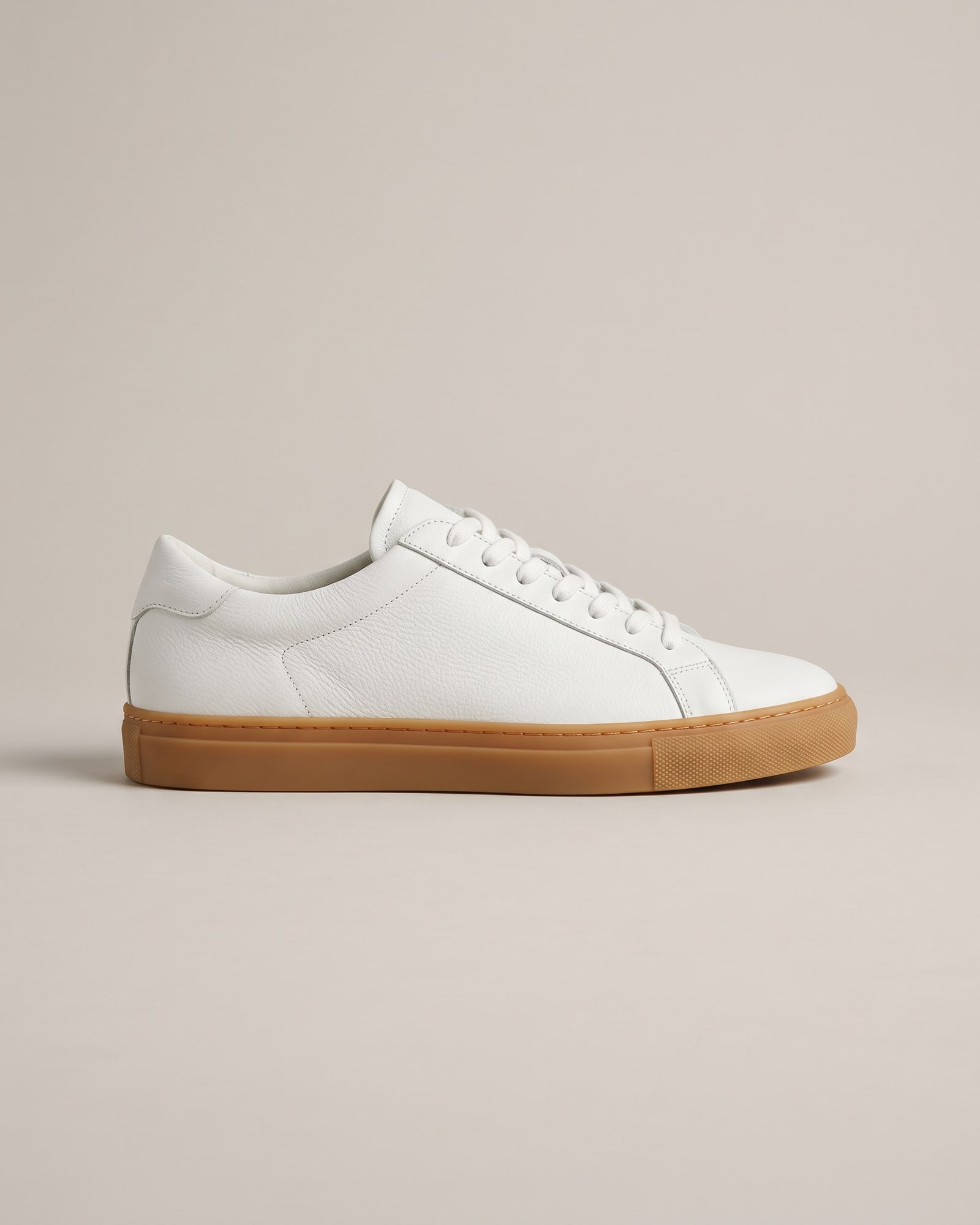 White leather sneaker with a gum sole on light grey